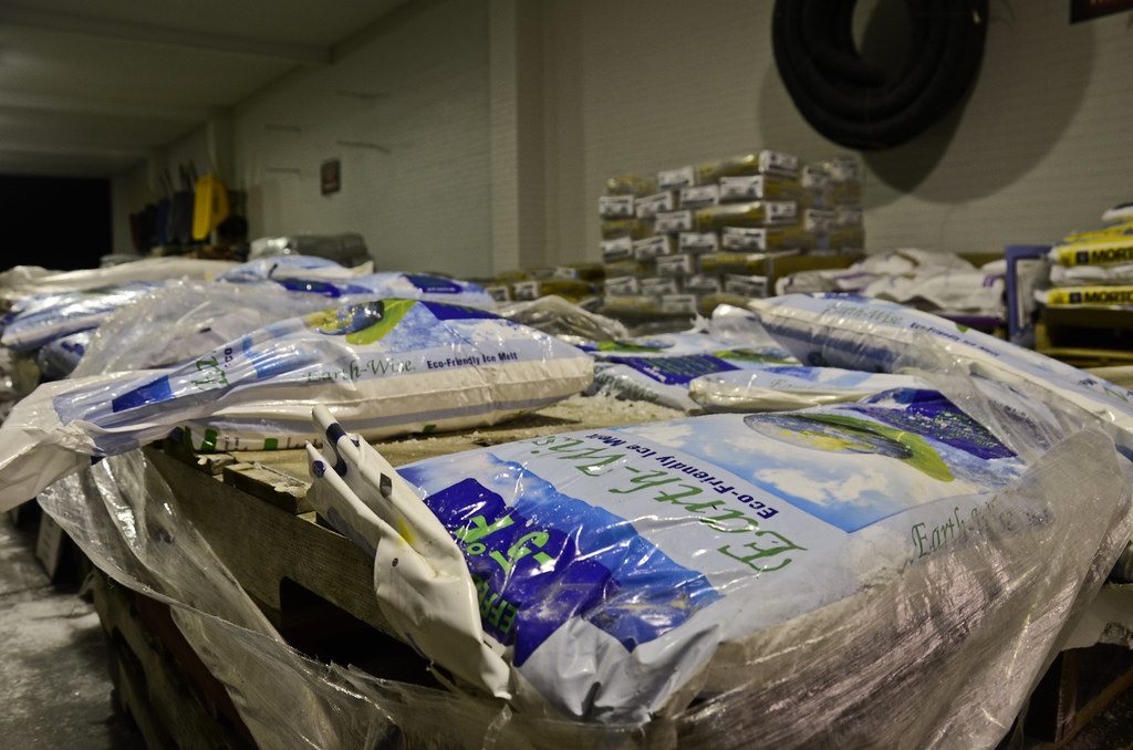 Bags of snow and ice melt salt stacked on warehouse pallets