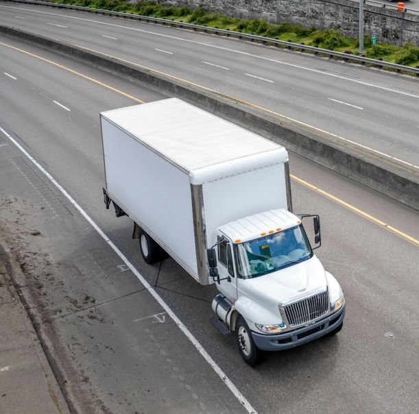 White box truck driving along a multi-lane highway